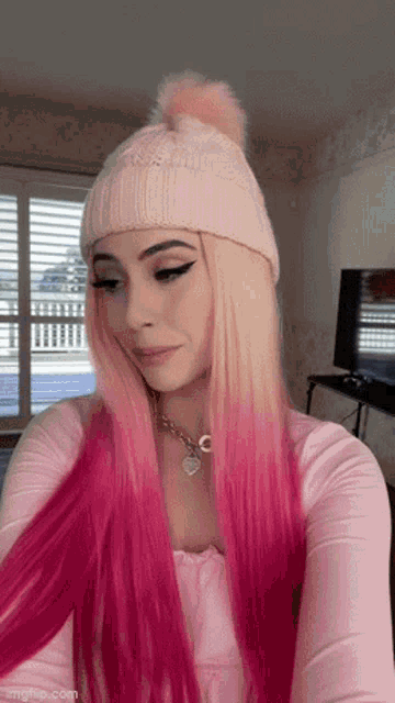 a woman with long pink hair wearing a pink hat