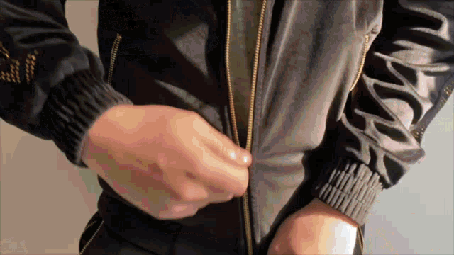 a person wearing a black jacket with a zipper on it