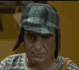 a close up of a man wearing a hat and a striped shirt .