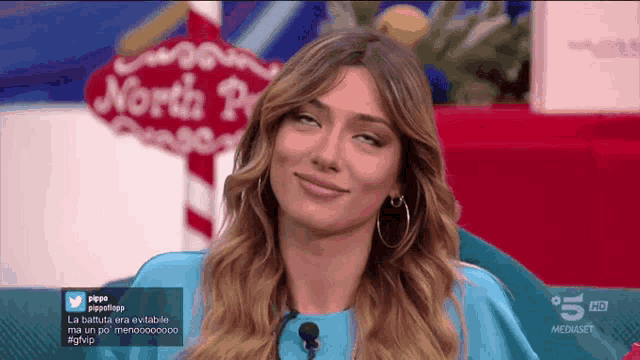 a woman is sitting in front of a sign that says north pole on it
