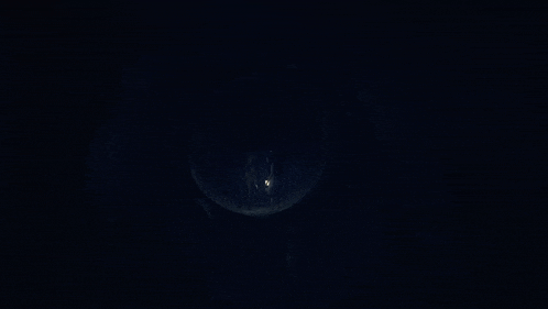 a person is standing in a dark room with a light shining through a window