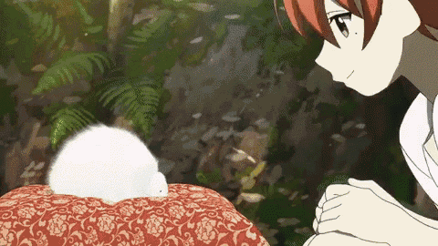 a girl with red hair looks at a white rabbit on a pillow