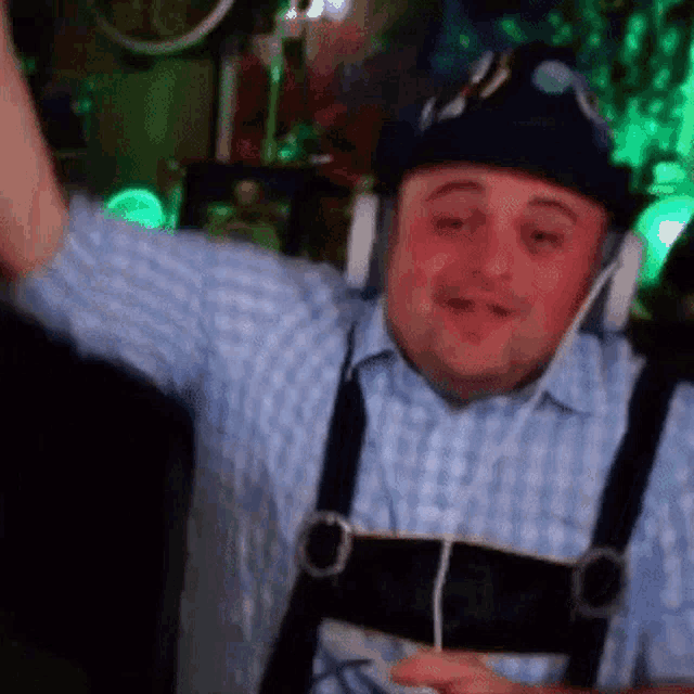 a man wearing headphones and a hat is dancing in a dark room .