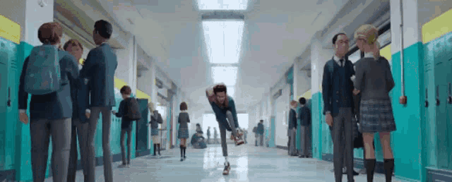 a group of people are walking down a hallway in a school building .