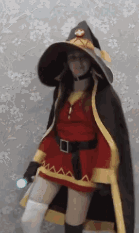 a woman in a witch costume is holding a blue light