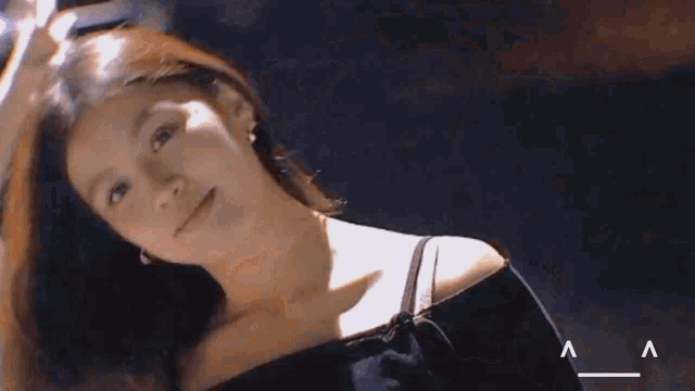 a woman in a black off the shoulder top with the letter a on the bottom right
