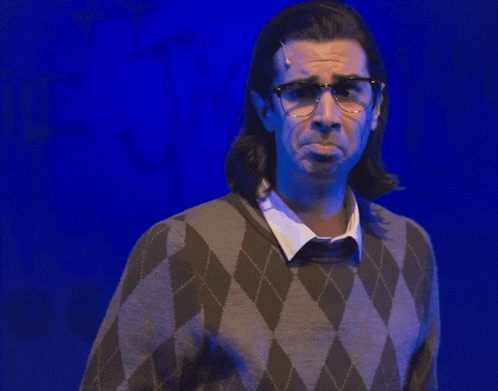 a man wearing glasses and a sweater with diamonds on it