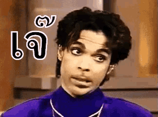 prince is wearing a purple turtleneck and necklace and making a funny face