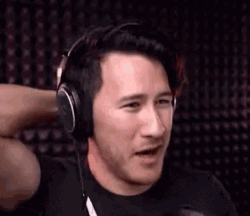 a man wearing headphones is making a funny face and looking at the camera .
