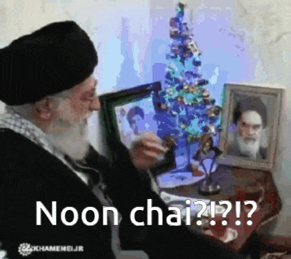 a man sitting in front of a christmas tree with the words noon chai on the bottom right
