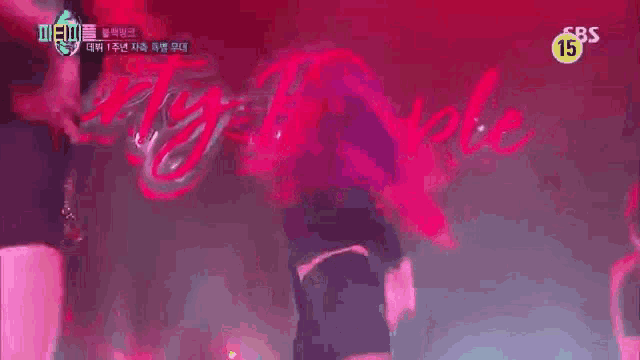 a woman is dancing on stage in front of a sign that says twenty people