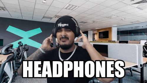a man wearing headphones in an office with the word headphones on the bottom