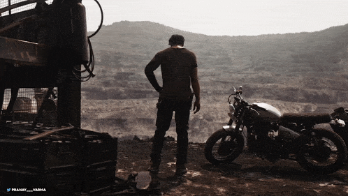 a man standing next to a motorcycle with the name pranav written on it