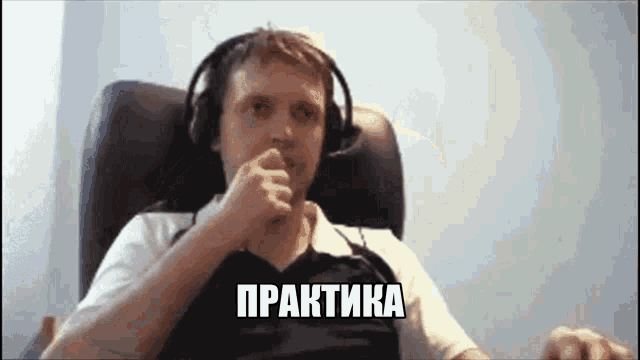 a man wearing headphones is sitting in a chair with his hand to his mouth and the word практика above him
