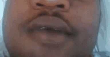 a close up of a person 's mouth with a play button in the corner .