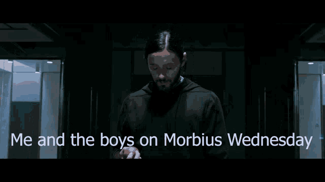 a man is standing in a dark room with the words me and the boys on morbidus wednesday