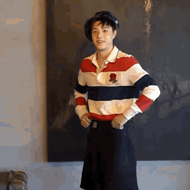 a young man wearing a striped shirt with a rose on it