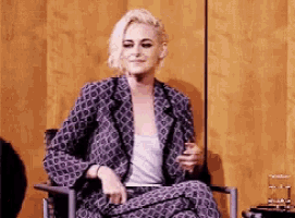 a woman is sitting in a chair with her legs crossed