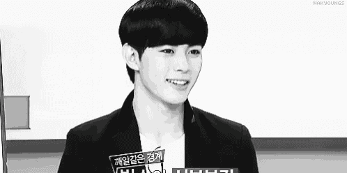 a black and white photo of a young man wearing a white shirt and a black jacket .