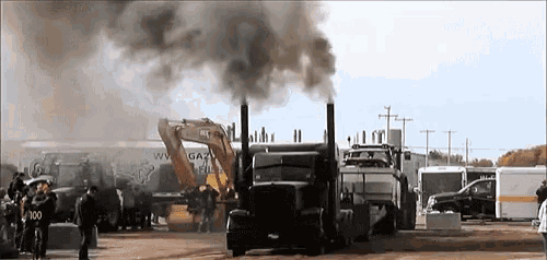 a truck with smoke coming out of the exhaust pipes is parked in a parking lot