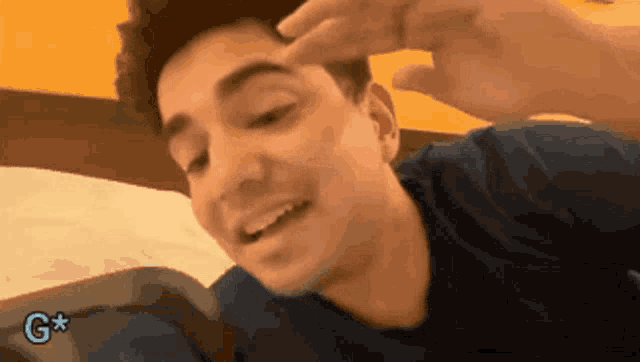a man laying on a bed with a g on the bottom