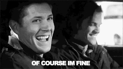 a black and white photo of two men laughing in a car and the words `` of course im fine '' .