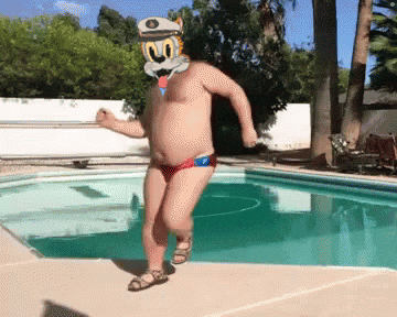 a shirtless man in a cartoon cat mask is dancing by a swimming pool