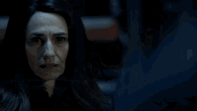 a woman in a dark room with a light coming out of the sky