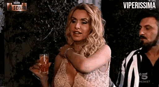 a woman in a dress is holding a glass of wine .