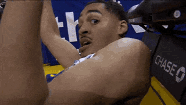 a basketball player stretches his arms in front of a chase sign