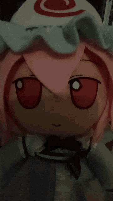 a stuffed toy with pink hair and red eyes