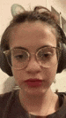 a close up of a girl wearing headphones and glasses .