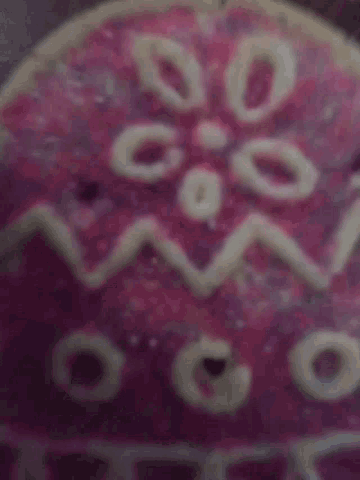a close up of a pink and white easter egg with the letters ss on it