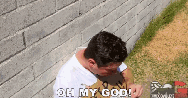 a man sitting in front of a brick wall with the words oh my god above him
