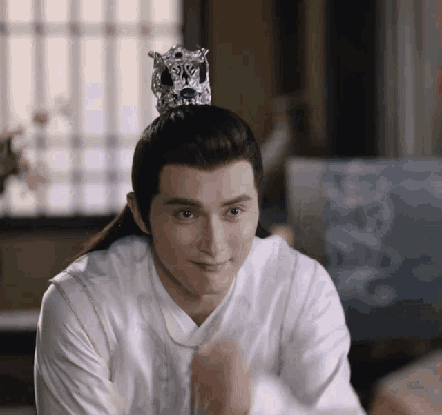 a man wearing a white shirt and a crown on top of his head