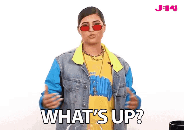 a woman wearing a denim jacket and a yellow shirt says what 's up