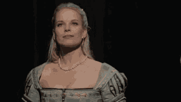 a woman with blonde hair and a pearl necklace