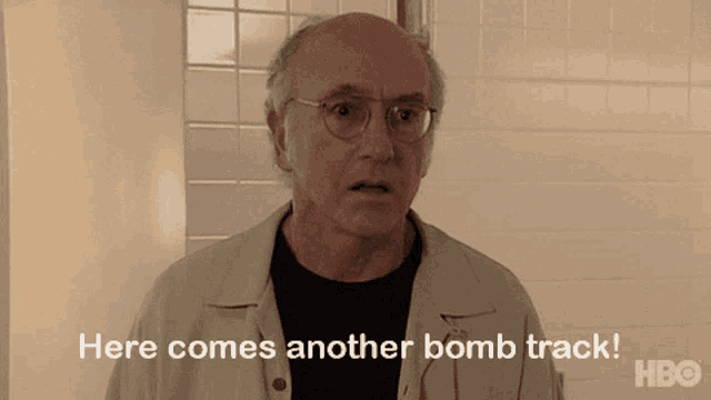 a man says here comes another bomb track in front of a tiled wall