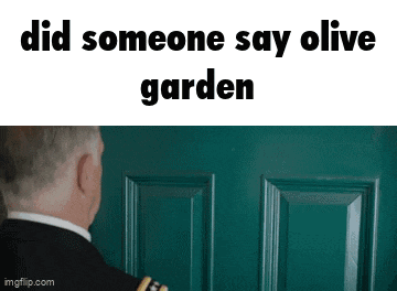 a man in a suit is standing in front of a green door and looking at it .