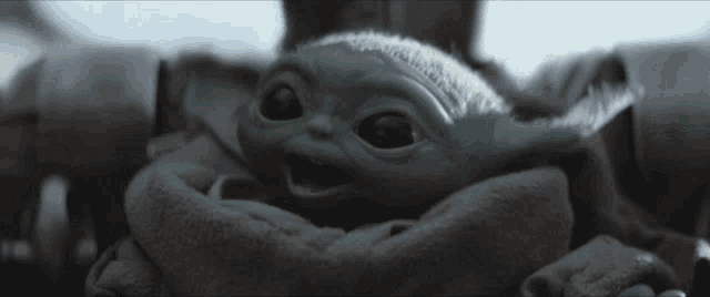a close up of a baby yoda with a surprised look on its face
