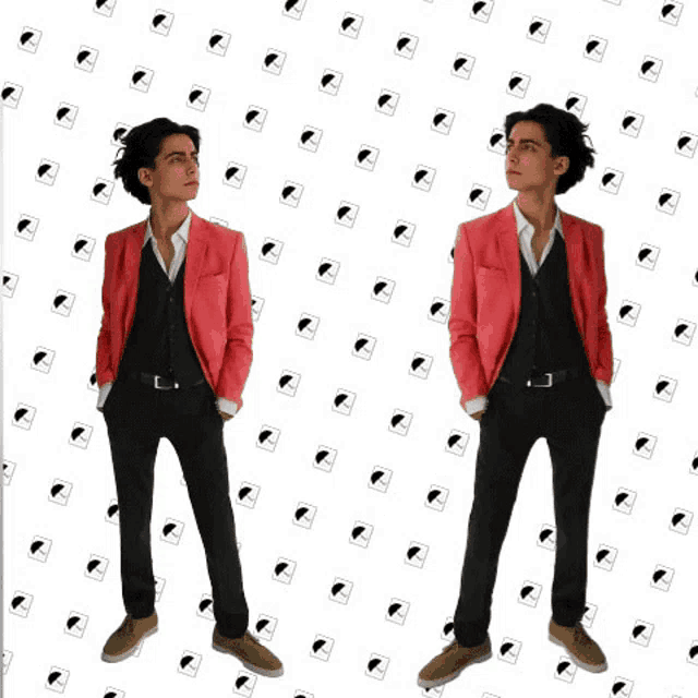 a man in a pink jacket is standing in front of a pattern of hearts