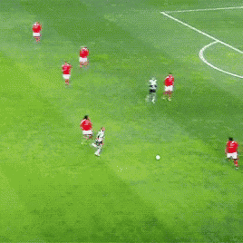 a group of soccer players playing on a green field