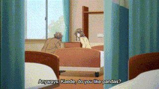 a girl is sitting on a bed in a hospital room talking to a boy .