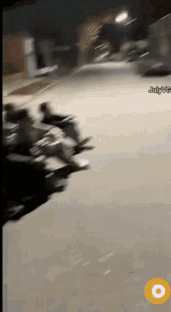 a blurred image of people riding motorcycles on a street with julywg written on the bottom