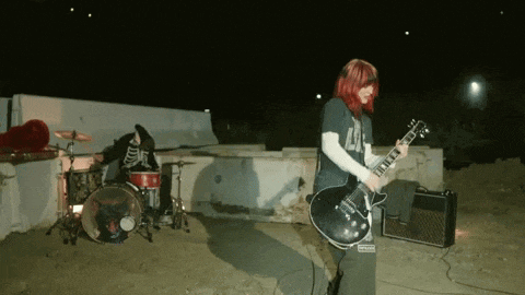 a woman with red hair is playing a guitar and wearing a shirt that says lg