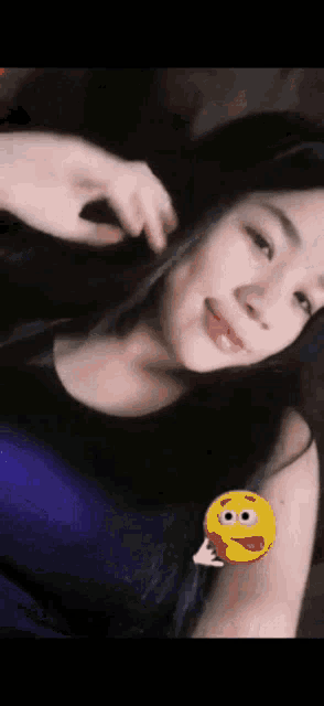a woman with a yellow smiley face on her arm .