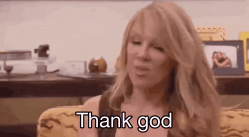 a woman is sitting on a couch saying thank god .