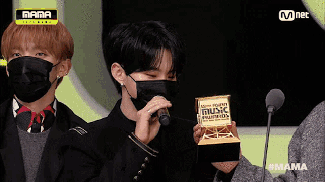 a man in a mask holds a trophy that says mama on it