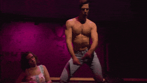 a man without a shirt is dancing on a stage