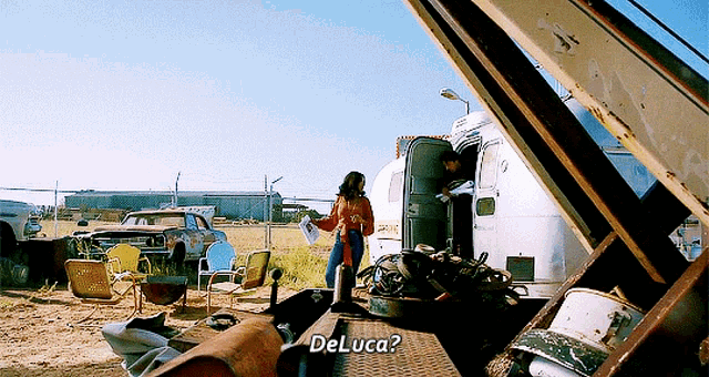 a woman standing in front of an airstream with the words deluca written on the side